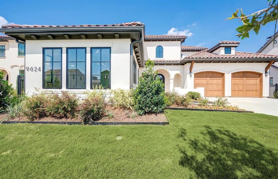 Mediterranean / spanish house featuring a garage and a front lawn