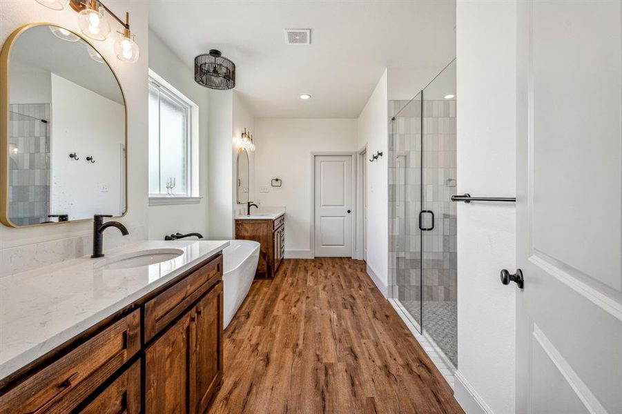 Bathroom with a shower with door, vanity, and hardwood / wood-style flooring