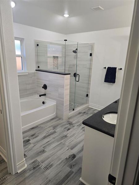 Bathroom featuring wood-type flooring, vanity, and independent shower and bath