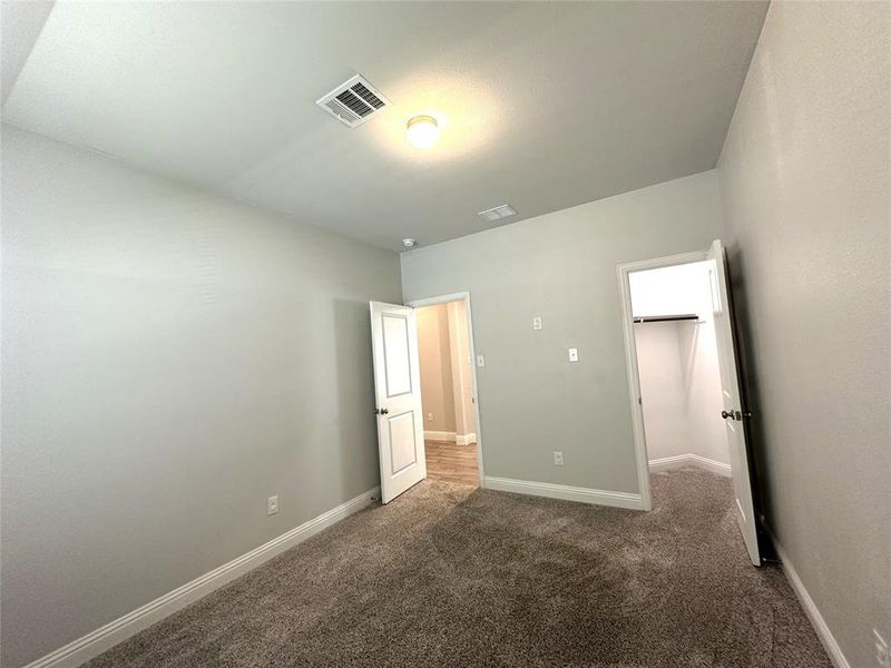 Unfurnished bedroom featuring dark carpet