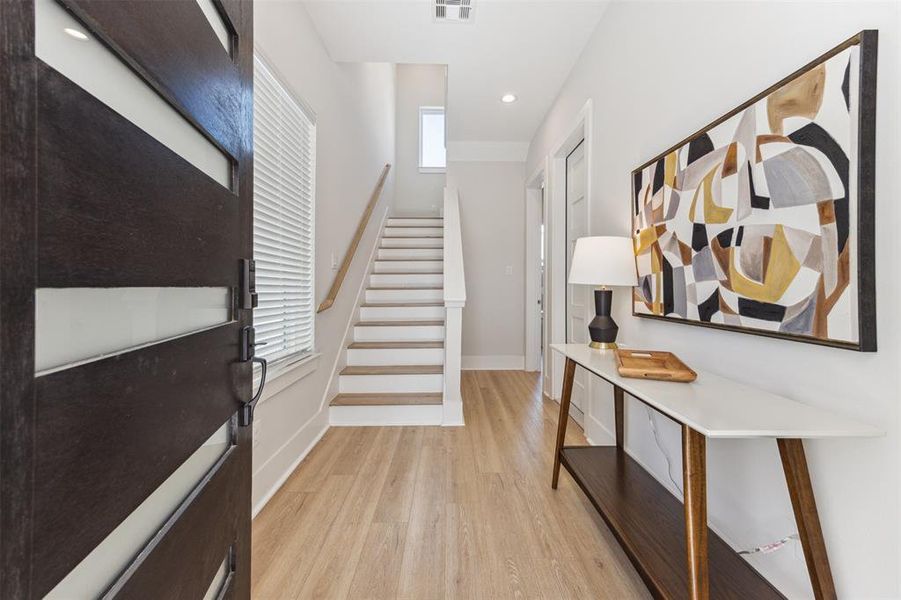 A sleek modern front door opens onto the welcoming foyer.