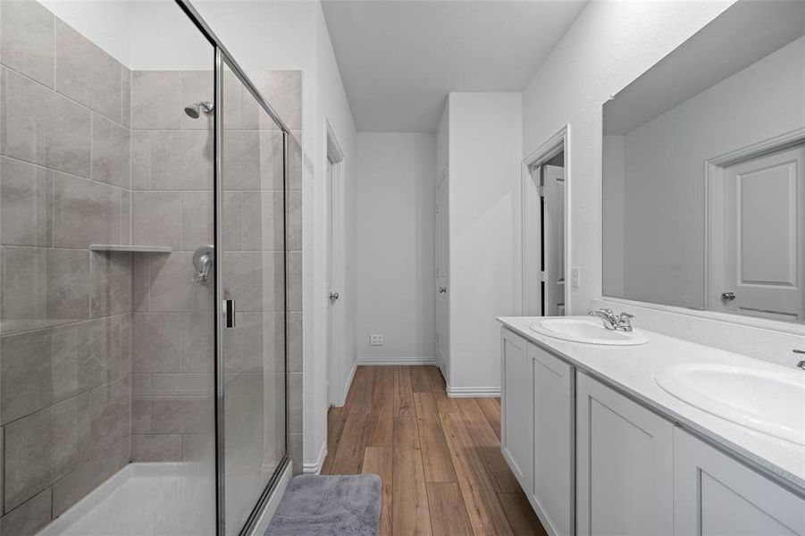 Bathroom with vanity, an enclosed shower, and wood-type flooring