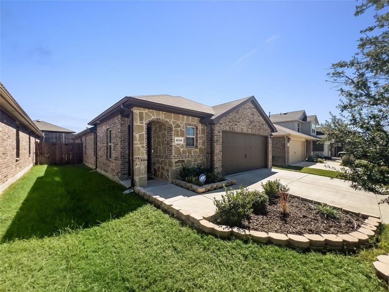 Ranch-style home featuring a garage and a front lawn