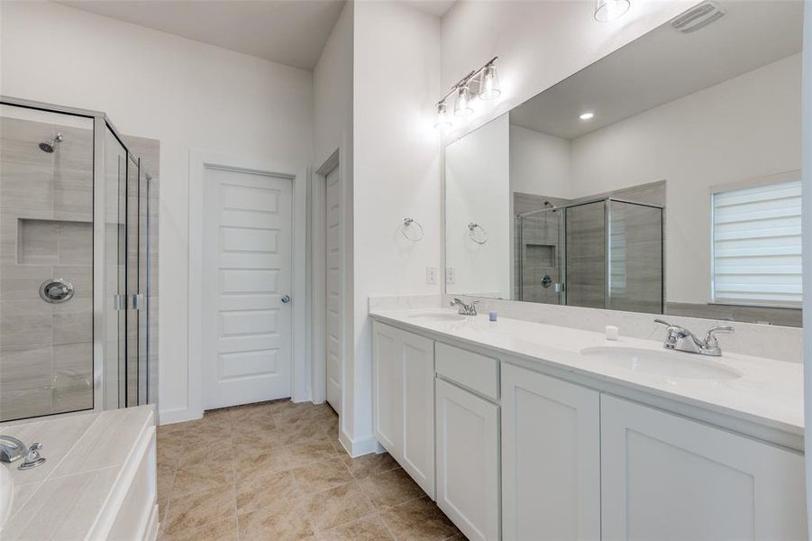 Bathroom with dual vanity, tile patterned flooring, and walk in shower