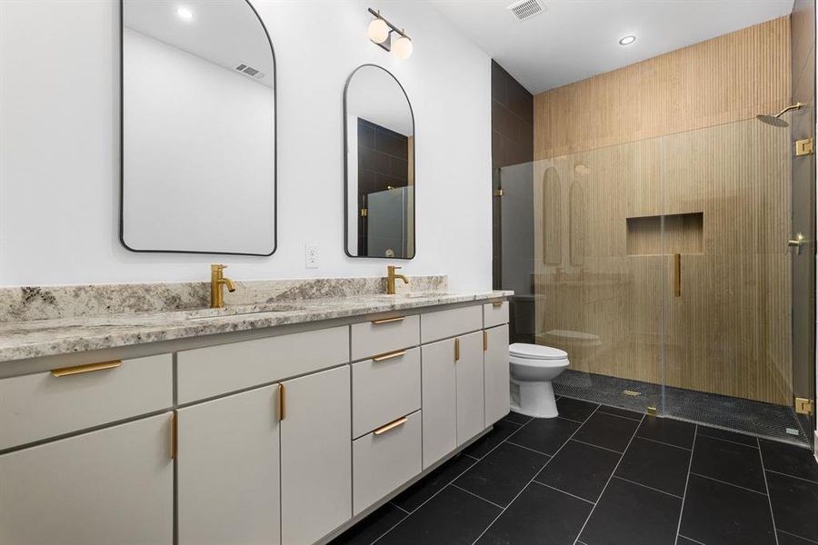 Bathroom with tile patterned floors, a shower with door, vanity, and toilet