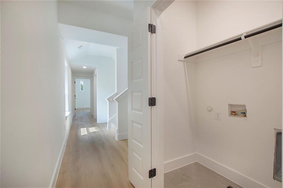 Laundry area with hookup for a washing machine, gas dryer hookup, and light hardwood / wood-style floors