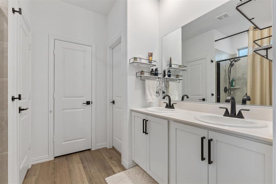 Bathroom featuring wood-type flooring, a shower with shower door, and vanity