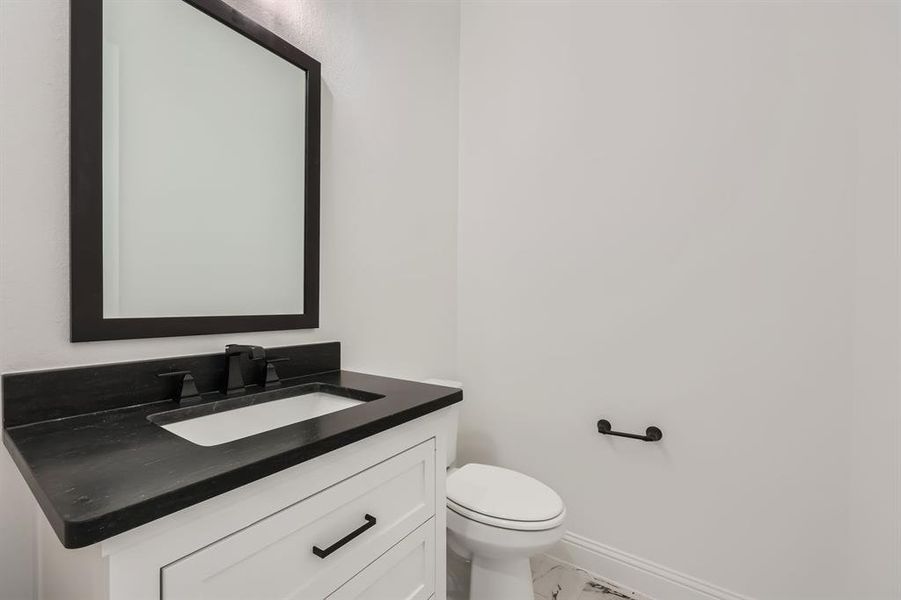 Powder bathroom with vanity and toilet