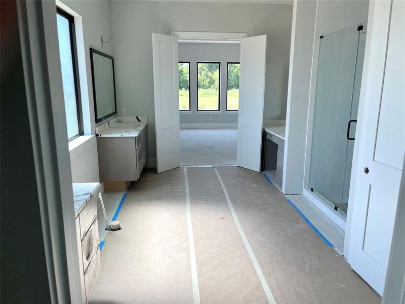 Primary bath with split vanities, a 67” soaking tub and an oversized shower. 2 closets complete the space.