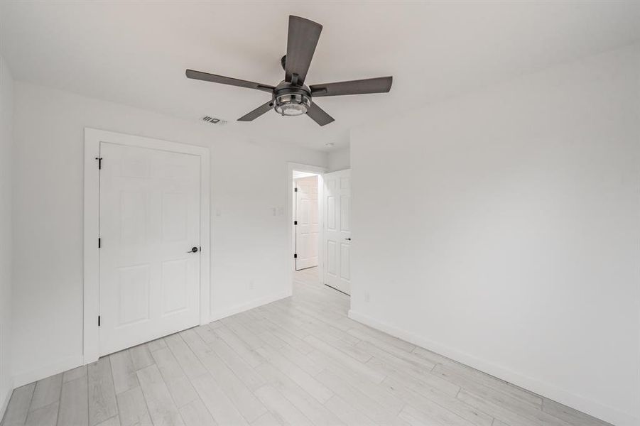 Unfurnished bedroom with ceiling fan, a closet, and light hardwood / wood-style flooring