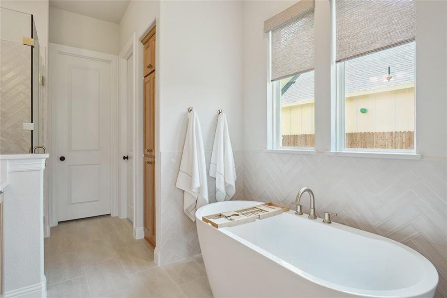 Bathroom with tile patterned flooring and a tub