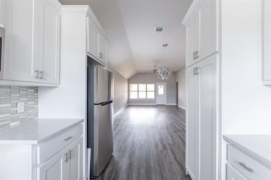 White kitchen , stone counter tops and cuson backsplash, cabinets to the ceiling!