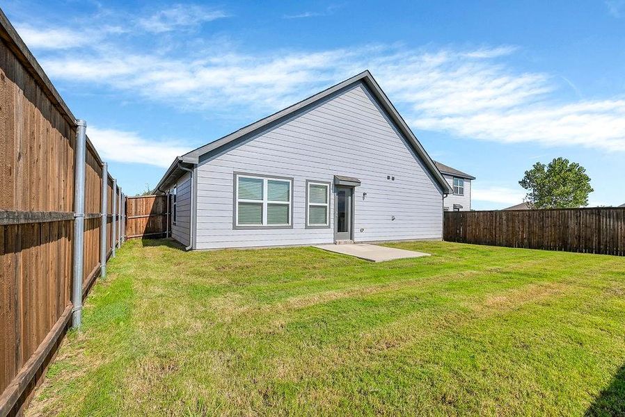 Back of house with a yard and a patio