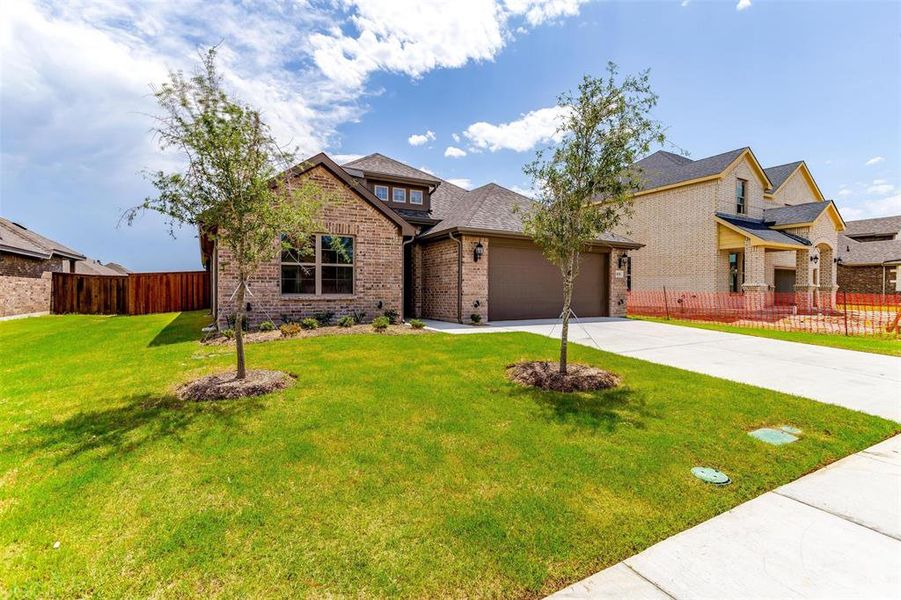 View of front of home featuring a garage and a front lawn