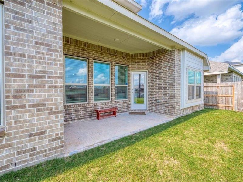 The neutral tones of the brick and wood create a seamless transition between the patio and the surrounding landscape. This cohesive design brings the outdoors in.