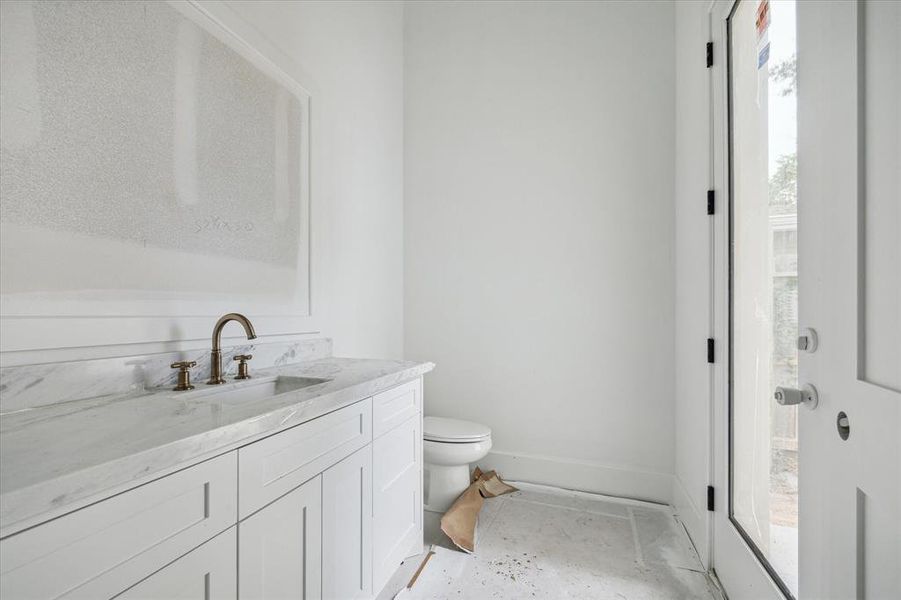 View of the powder room with side yard access.  This powder room is nicely tucked away for privacy for your guests and also allows private, side yard access making it perfect for your future pool bath and for everyday outdoor play and entertaining.  Photo as of 9/3/2024