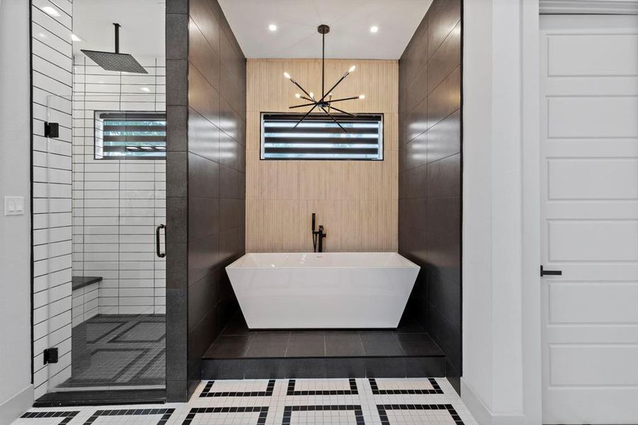 The primary bath offers extra ordinary features and design details working together to create a true retreat with  separate seamless glass shower and spa style soaker tub.