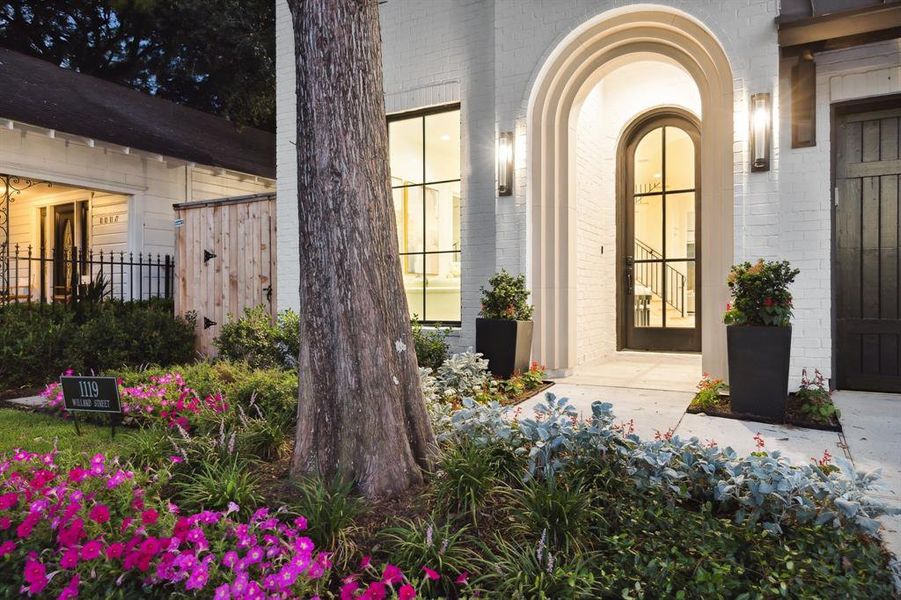 Closer view of the entrance of the home. There is a Mahogany Stained front door with a rounded top and 6 divided lite windows.