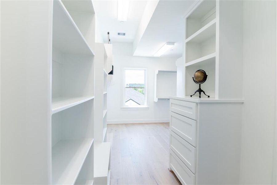 Primary closets feature convenient custom dressers and built-ins with metal rods.