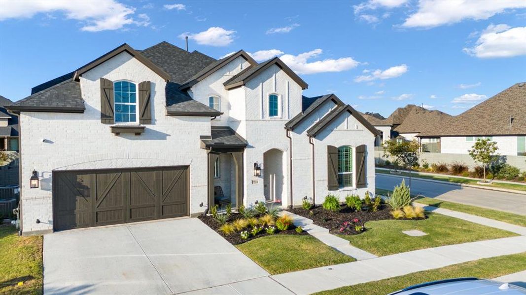 View of front facade featuring a front lawn and a garage