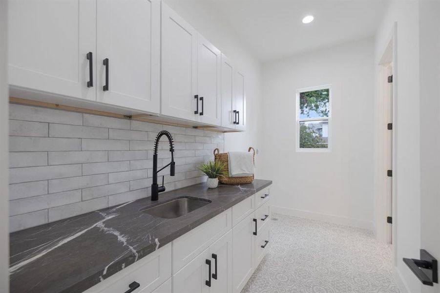 Direct access to this laundry room from the primary suite makes doing laundry a breeze.