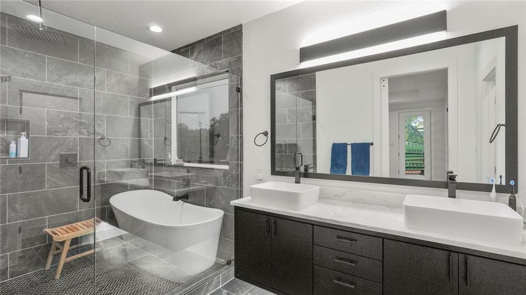 Bathroom with tile patterned flooring, tile walls, dual vanity, and plus walk in shower