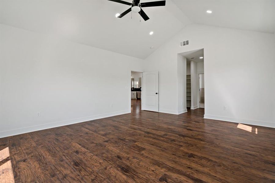 featuring dark hardwood / wood-style flooring, high vaulted ceiling, and ceiling fan