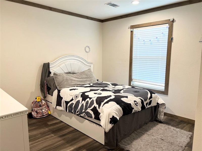 Bedroom featuring ornamental molding and dark hardwood / wood-style floors