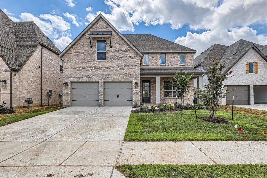 View of front of property with a garage and a front lawn