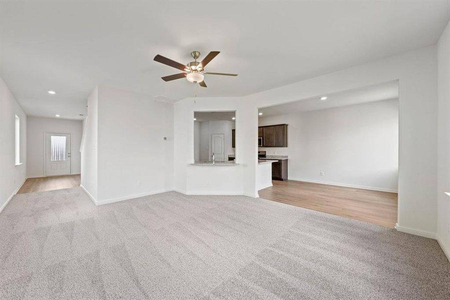 Living room featuring ceiling fan and light carpet