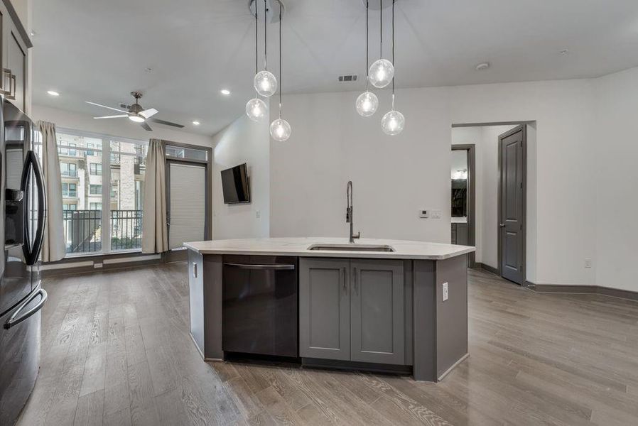Kitchen featuring dishwasher, fridge, hardwood / wood-style floors, gray cabinets, and sink