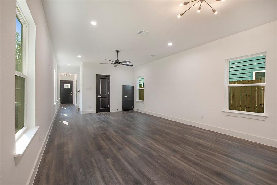 Unfurnished living room featuring ceiling fan and dark hardwood / wood-style floors