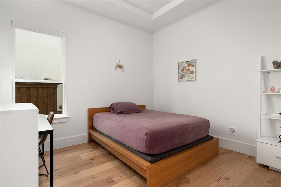 Bedroom with light hardwood / wood-style flooring & private en suite bathroom