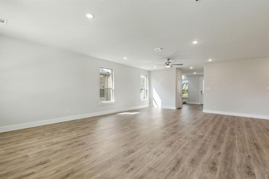 Unfurnished living room featuring ceiling fan and light hardwood / wood-style floors