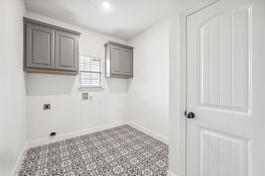 Laundry room with cabinets, hookup for a washing machine, electric dryer hookup, and light tile patterned floors