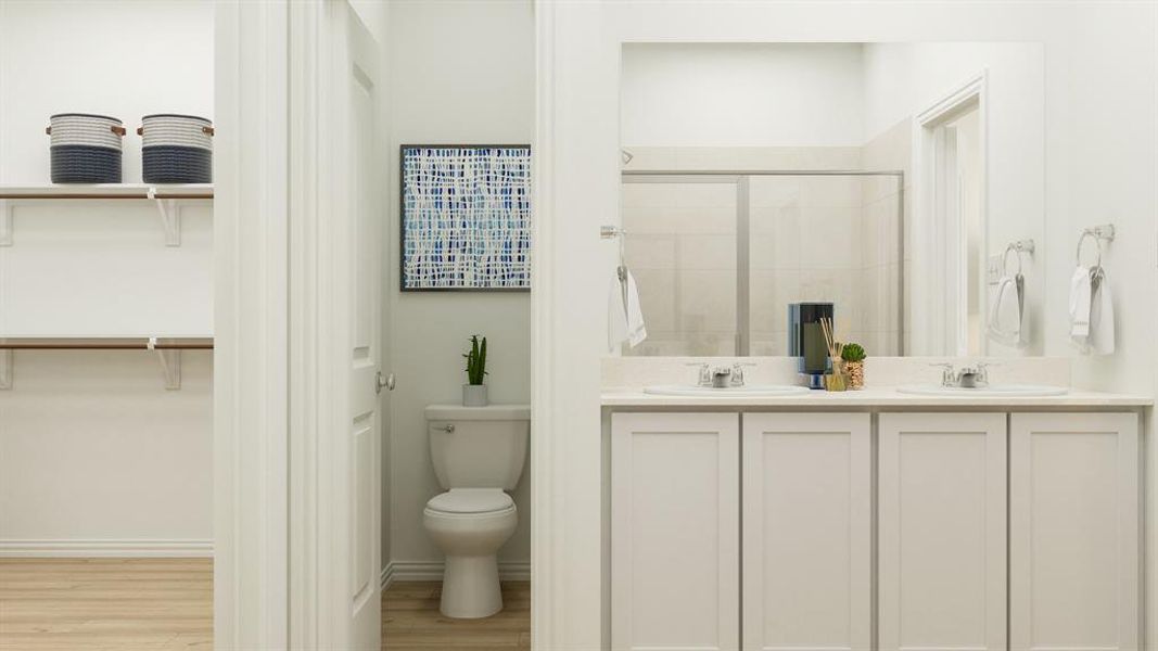 Bathroom with dual vanity, toilet, and hardwood / wood-style floors