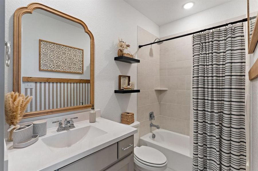 Full bathroom with vanity, toilet, and shower / bath combination with curtain