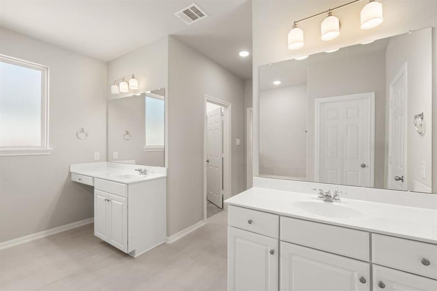 The en-suite bathroom offers a spa-like atmosphere with its elegant design, high end finishes, and tasteful lighting, creating a retreat within your own home.