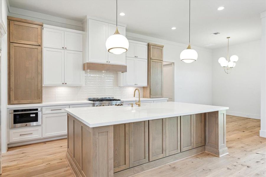 The kitchen is open to the living room and offers a single slab island atop a white oak stained cabinet base.