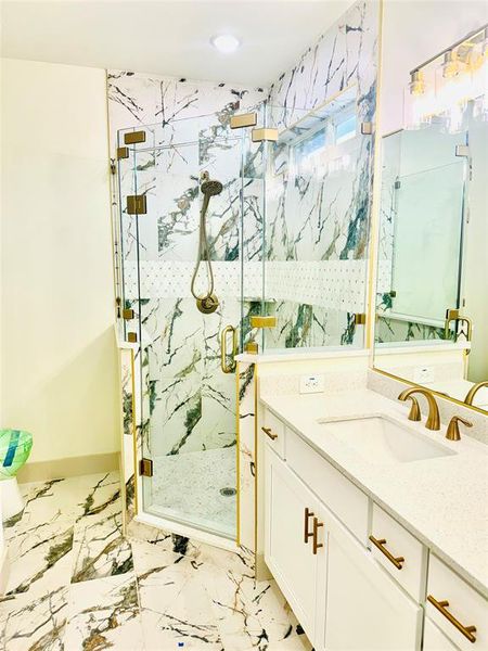 Bathroom featuring vanity and a shower with door