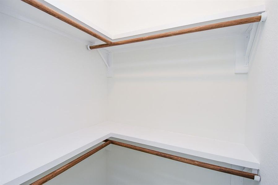 View of the custom-made closet featuring a built-in clothing rack and shelves for additional storage.