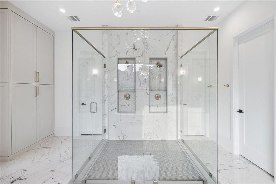 The centerpiece of the bathroom is a huge walk-in shower, encased in frameless glass closure, where cascading water envelops you in a soothing embrace. Sleek fixtures and luxurious materials combine to create an oasis of tranquility and rejuvenation, offering the perfect escape from the stresses of the day.