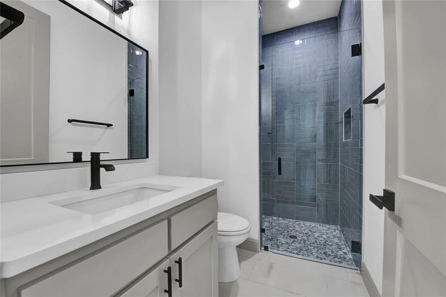 Bathroom with vanity, toilet, and a shower with door