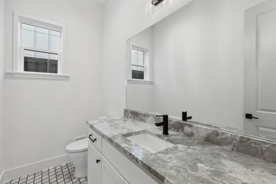 Bathroom with vanity, toilet, and tile patterned floors