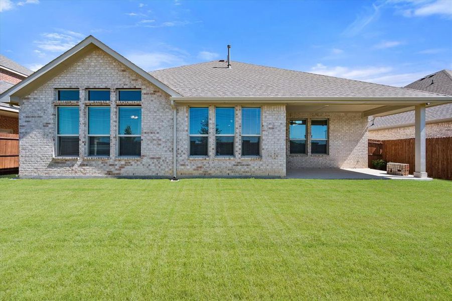 Rear view of property with a yard and a patio area