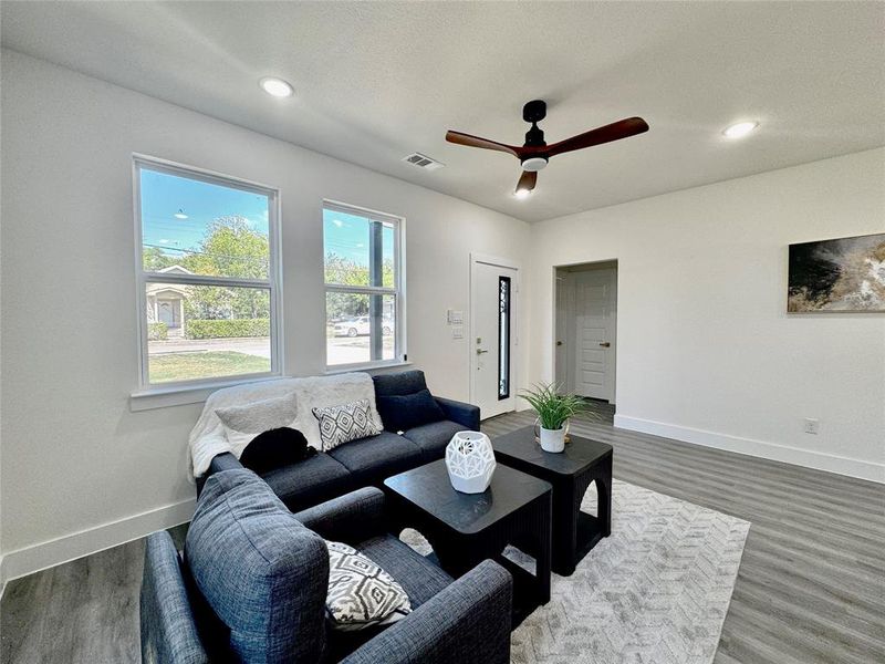 Living room with ceiling fan and hardwood / wood-style floors