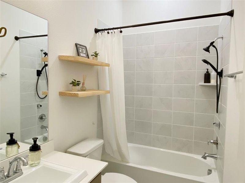 Full bathroom with vanity, toilet, and shower / bath combination with curtain