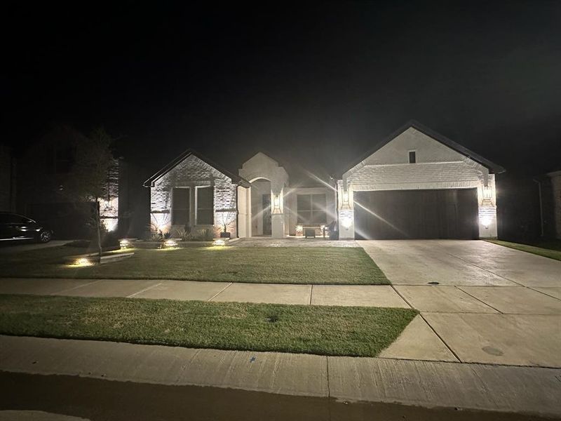 View of front of house with a garage and a lawn