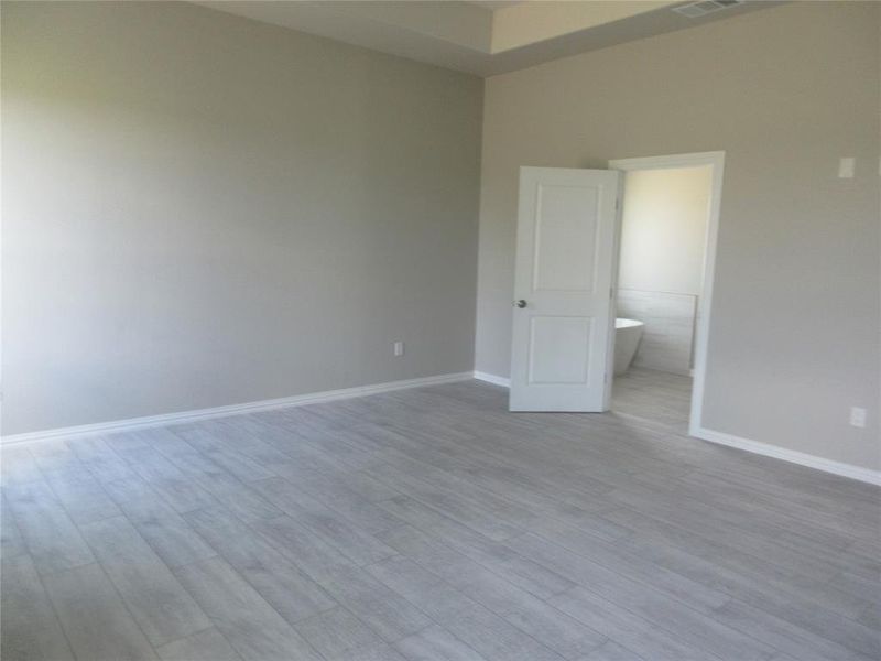 Unfurnished room featuring light wood-type flooring and a towering ceiling