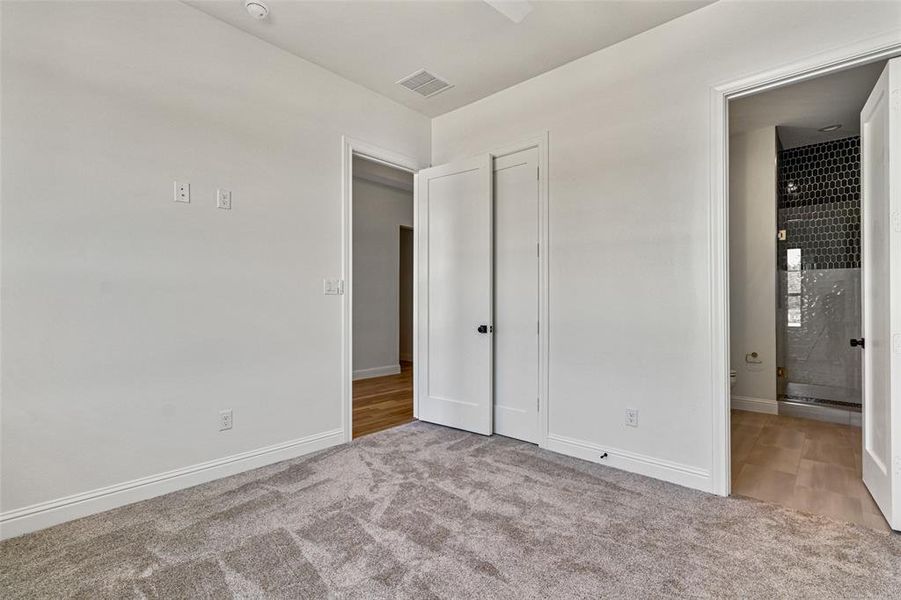 Unfurnished bedroom featuring light colored carpet